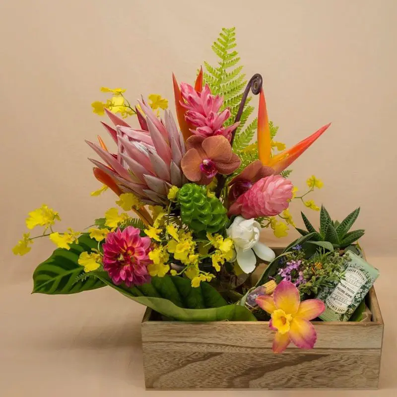 A flower gift hamper in a wooden box with a note