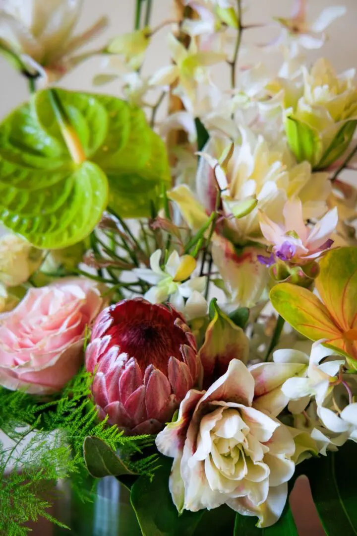 A close up of flowers and leaves in the vase