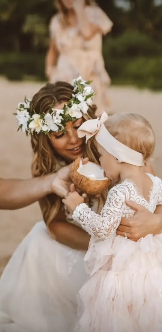 A woman holding a child and a coconut.