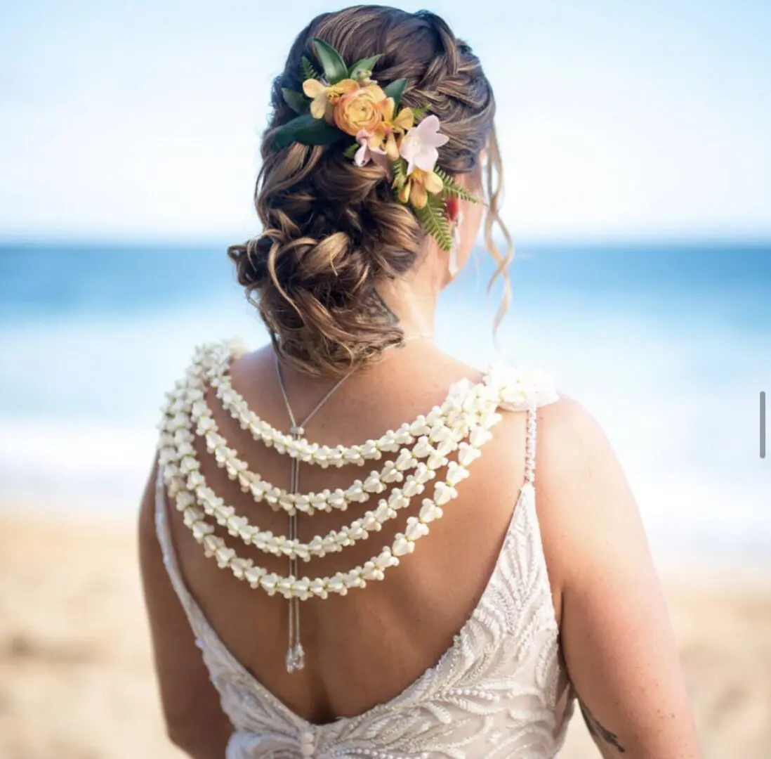 A woman with long hair and pearls on her back.